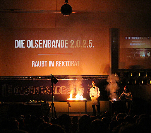 Zwei Darsteller machen ein Feuerexperiment.