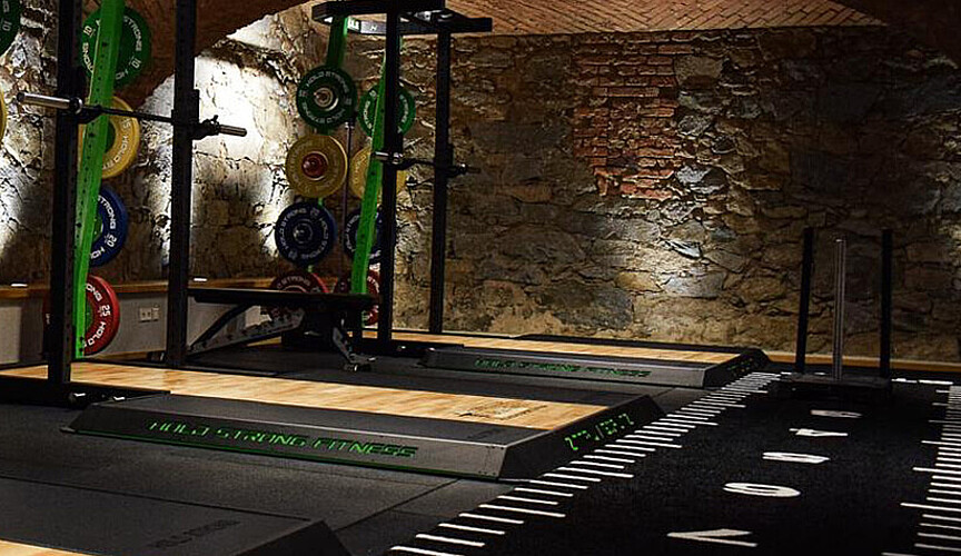 Hantelplattform vor einer Gewölbemauer