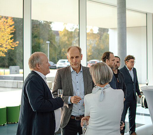 Gäste der Veranstaltung sind im Gespräch vertieft.