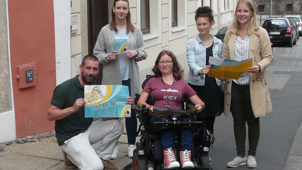 Junge Leute halten Stadtkarte der Görlitzer Altstadt für Menschen mit eingeschränkter Mobilität in der Hand.