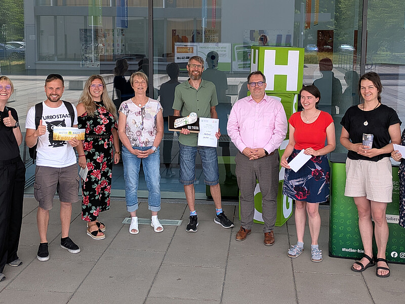 Der Rektor, Vertreter vom Gesundheitsmanagement der Hochschule und Teilnehmende stehen zum Gruppenfoto nebeneinander vor Haus vier.