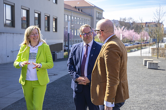 Prorektorin, Rektor und Herr Denk gehen am Zittauer Campus entlang und unterhalten sich.